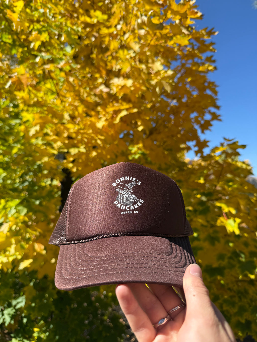 Bonnie's Powder Stack Trucker hat front view featuring Aspen Mountain shredding girl logo
